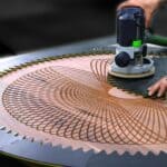 large walnut coffee table with a deep geometric spirograph carving, created using a custom 3D printed router jig and a woodworking router.