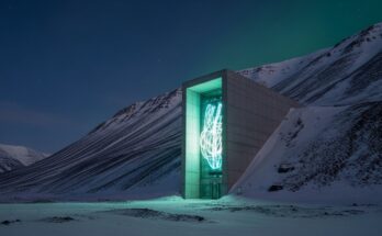 The illuminated entrance of the Svalbard Global Seed Vault in the snow.