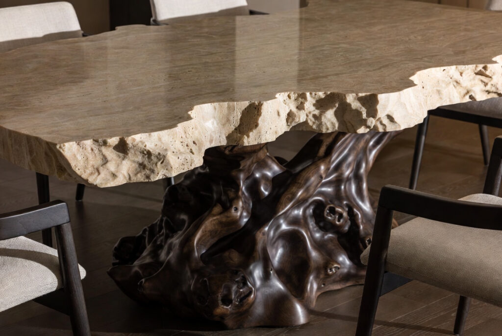 Close-up of sculptural stone dining table with organic curved dark wood base 2026 luxury trend